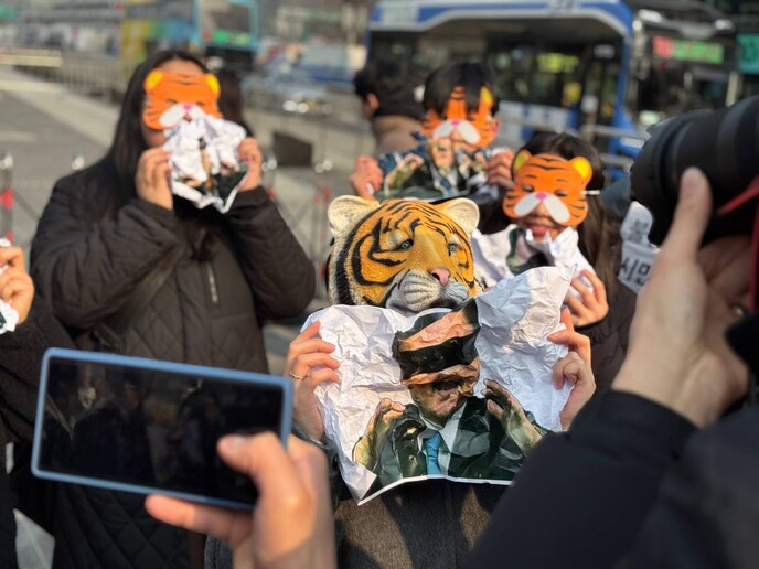 13일 범청년행동이 기자회견을 마친 후 호랑이 가면을 쓰고 윤석열 대통령을 물어가는 퍼포먼스를 진행하고 있다. 범청년행동 제공.